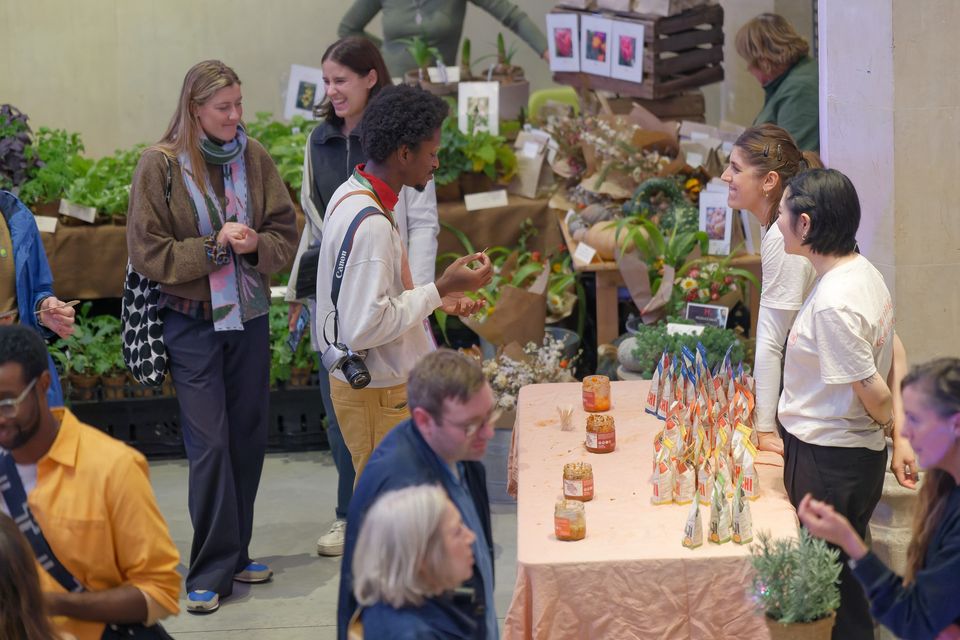 Visitors talking with growers beside their market stall
