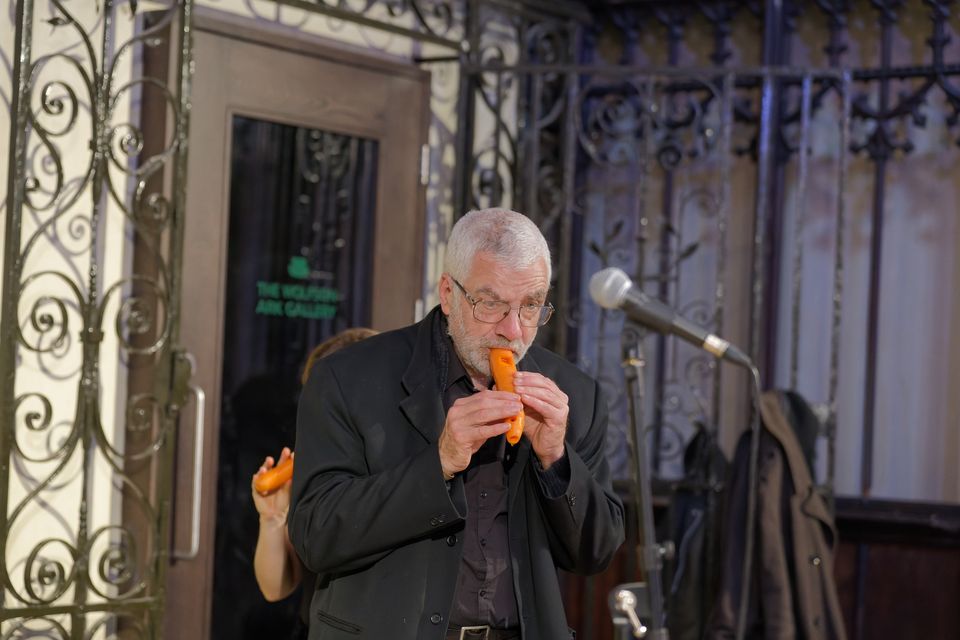 A musician playing a carved carrot in the vegetable orchestra